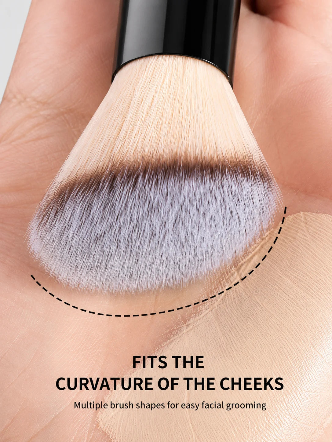 A close-up of a fluffy makeup brush with soft bristles fitting the curve of the cheek for facial grooming.