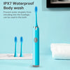 A blue sonic electric toothbrush with replaceable heads is shown next to a white towel on a light blue surface.