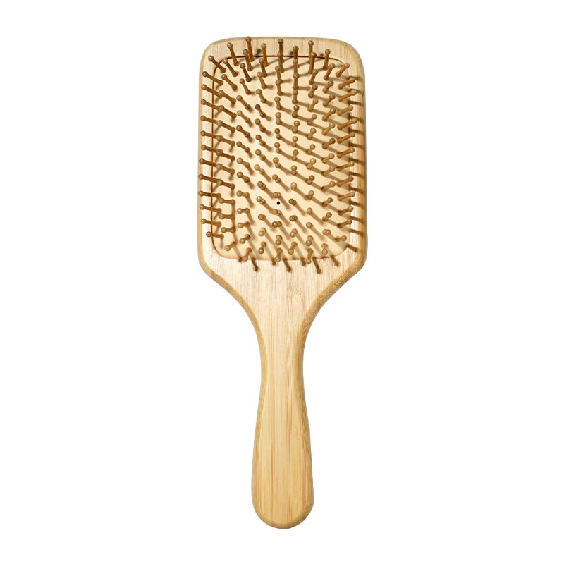 A light brown bamboo hair brush with fine bristles for detangling and scalp massage.