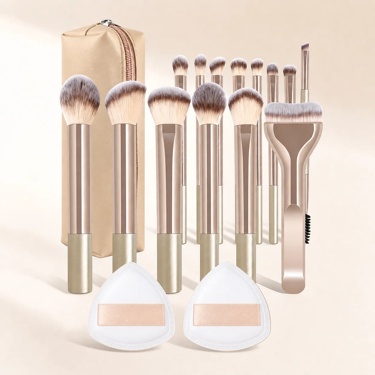 A collection of 17 makeup brushes and powder puffs in gold and beige tones displayed against a light background.