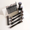 A collection of professional makeup brushes including foundation and eyeshadow brushes displayed on a white surface.