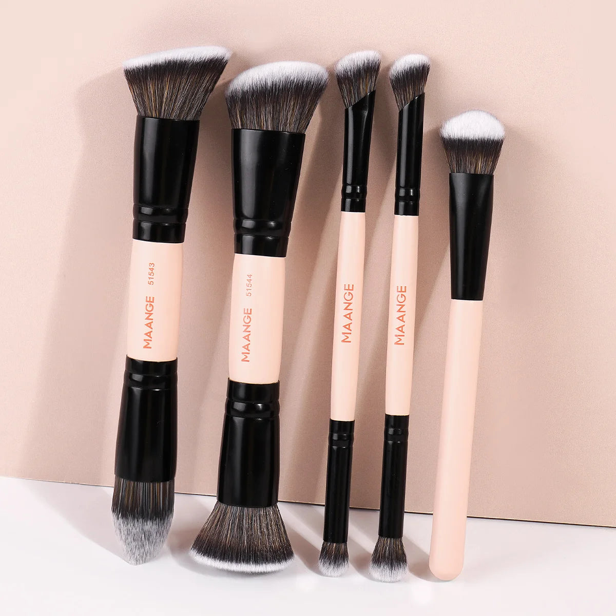 A set of five professional synthetic makeup brushes with black handles and light pink bristles displayed against a neutral ba