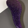 A purple, glittery duster brush is shown against a gray background.