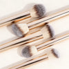 A set of 17 makeup brushes and a powder puff with light wooden handles and fluffy bristles.