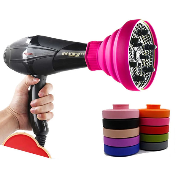 Une main tient une housse de séche-cheveux en silicone rose et noir avec plusieurs tasses en silicone colorées.