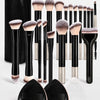 A collection of black and silver makeup brushes with soft bristles displayed next to a black zippered case and silicone brush