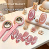 A collection of pink circular magnetic nail art sticks and decorative cat figurines displayed on a white surface.