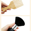 A wooden grooming brush and a black duster brush are shown being held by a hand.