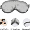 Masque de sommeil en soie grise avec sangle réglable, montrant son ajustement et son ombrage.