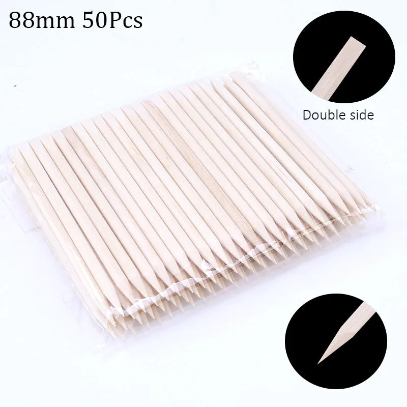 A flat arrangement of 50 natural wood nail art pusher sticks, showing a double-sided view.