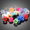 A collection of colorful flexible silicone ear tunnels and plugs in various shades including pink, purple, green, orange, and