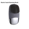 A gray electric facial cleansing brush with a textured head and a silver base.