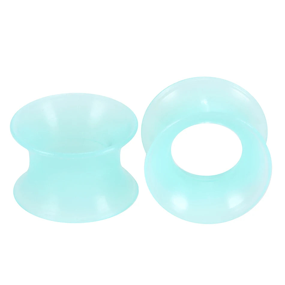 A pair of translucent light blue flexible silicone ear tunnels and plugs.