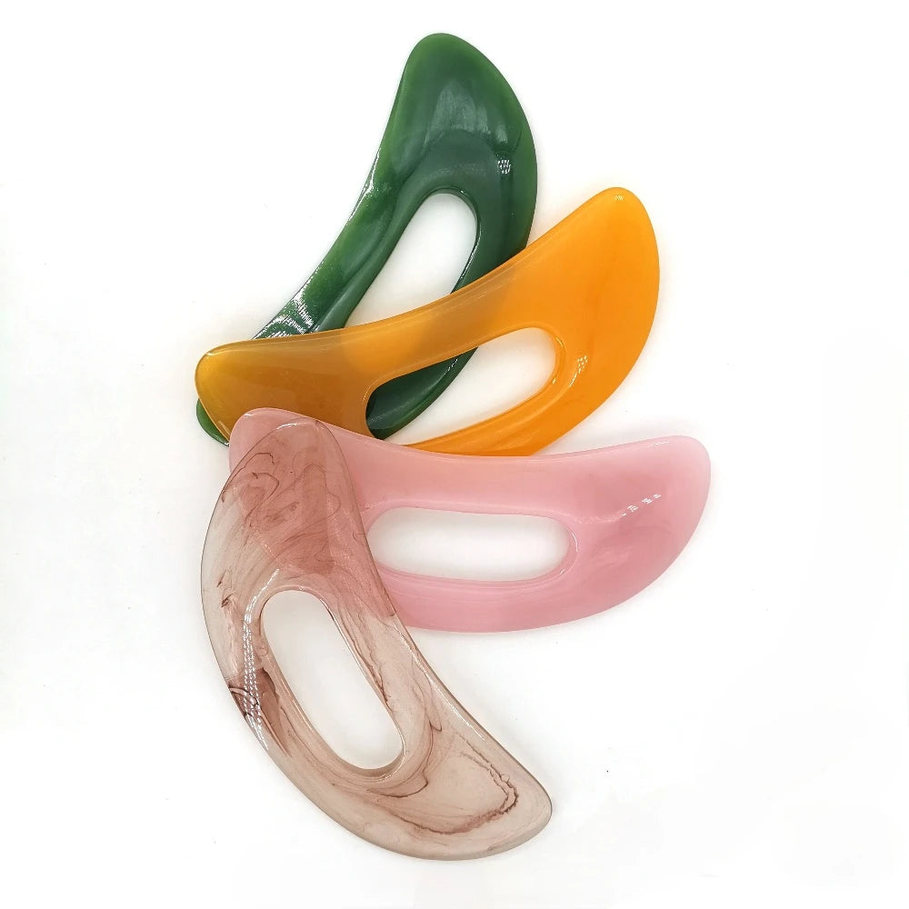 Trois planches de massage incurvées en pierre naturelle aux tons de vert, orange et rose.