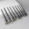 A set of professional makeup brushes for contouring and highlighting, arranged diagonally on a white surface.