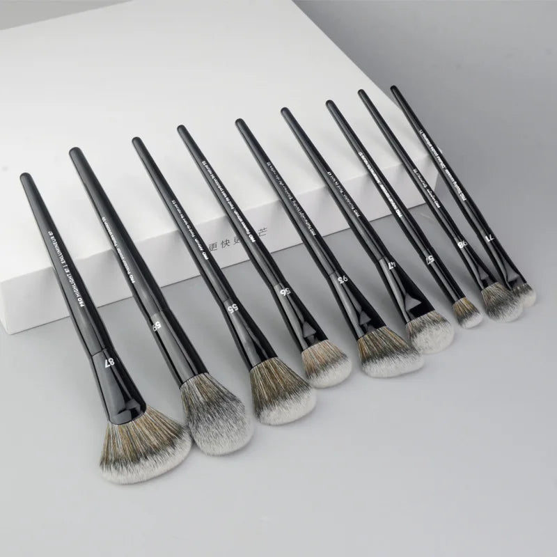 A set of professional makeup brushes for contouring and highlighting, arranged diagonally on a white surface.