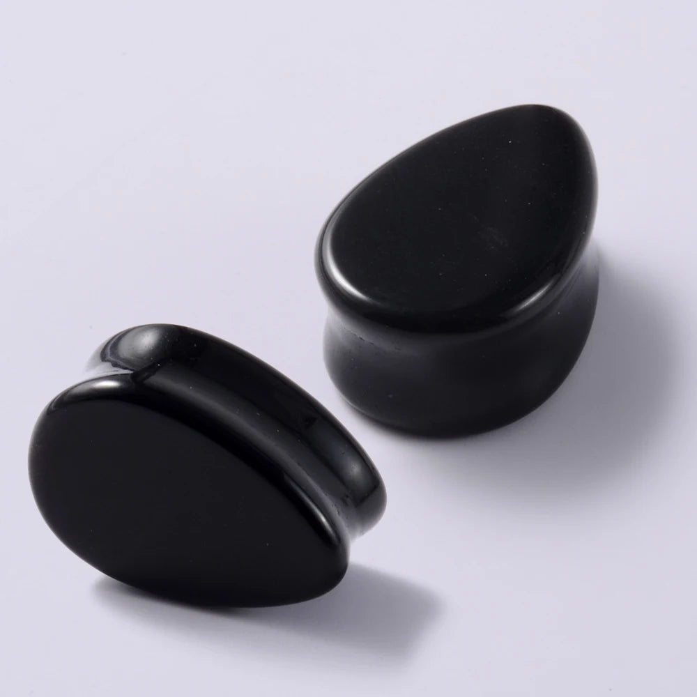 Un par de dilatadores para los lóbulos de la oreja de piedra negra, vistos desde arriba.