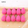 50 pieces of pink makeup sponge puffs arranged in a row on a beige fabric background