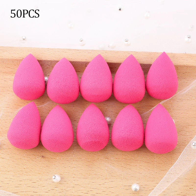 50 pieces of pink makeup sponge puffs arranged in a row on a beige fabric background