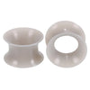 A pair of translucent silicone ear tunnels and plugs for hearing aid or custom ear devices.