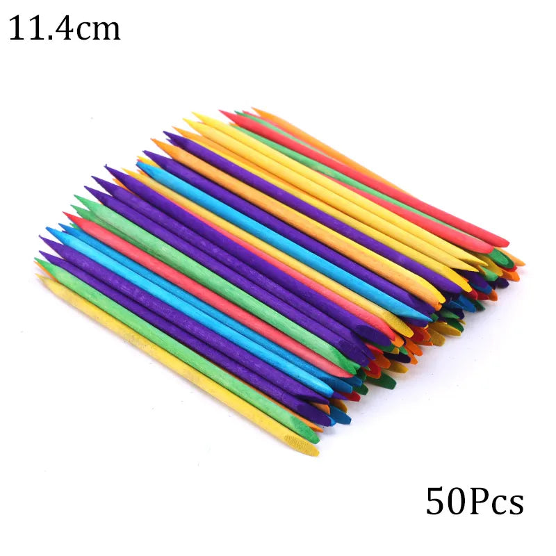 A fan of colorful wooden nail art pusher sticks arranged diagonally.