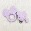 Teether en silicone violet en forme de papillon avec un petit charm pour le soin oral du bébé.