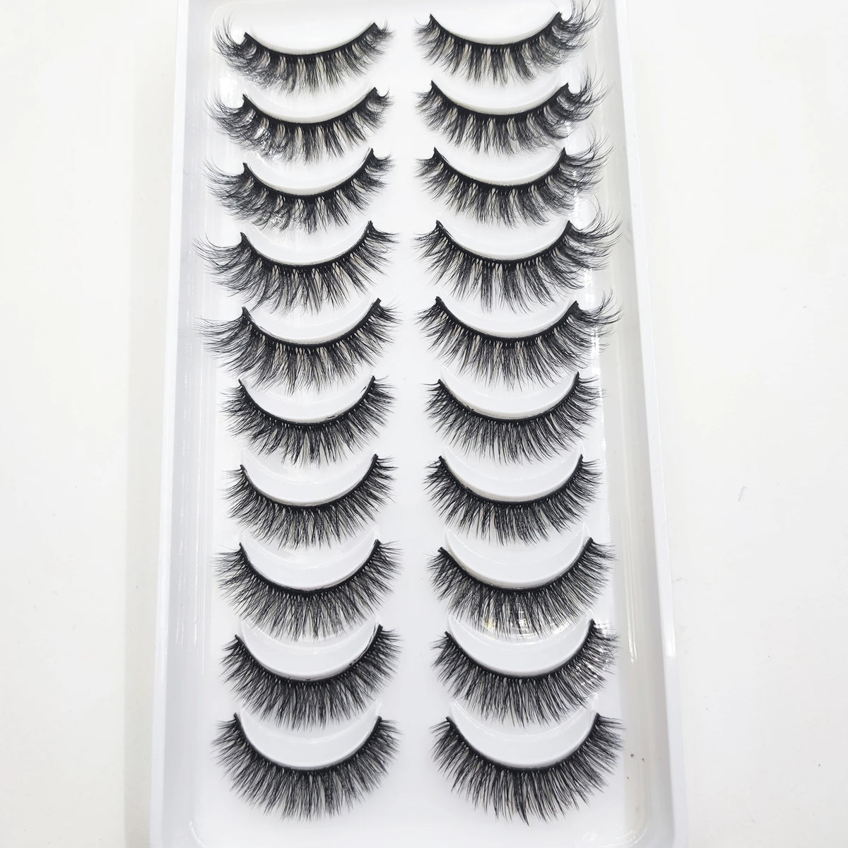 A plastic tray holding a set of natural mink false eyelashes in various styles and lengths.