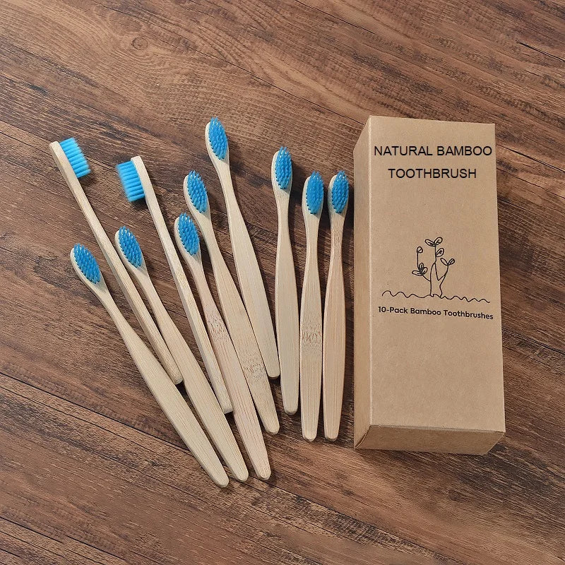 Une boîte de dix brosses à dents en bambou naturelles est exposée sur une surface en bois.