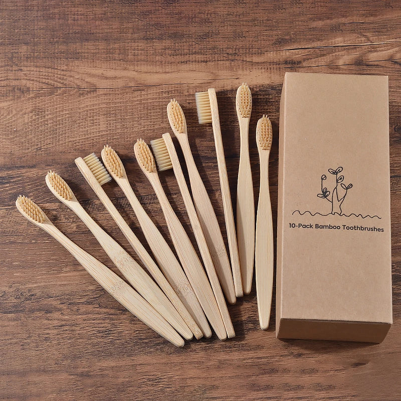 Une boîte en carton contenant dix brosses à dents en bambou disposées en diagonale sur une surface en bois.