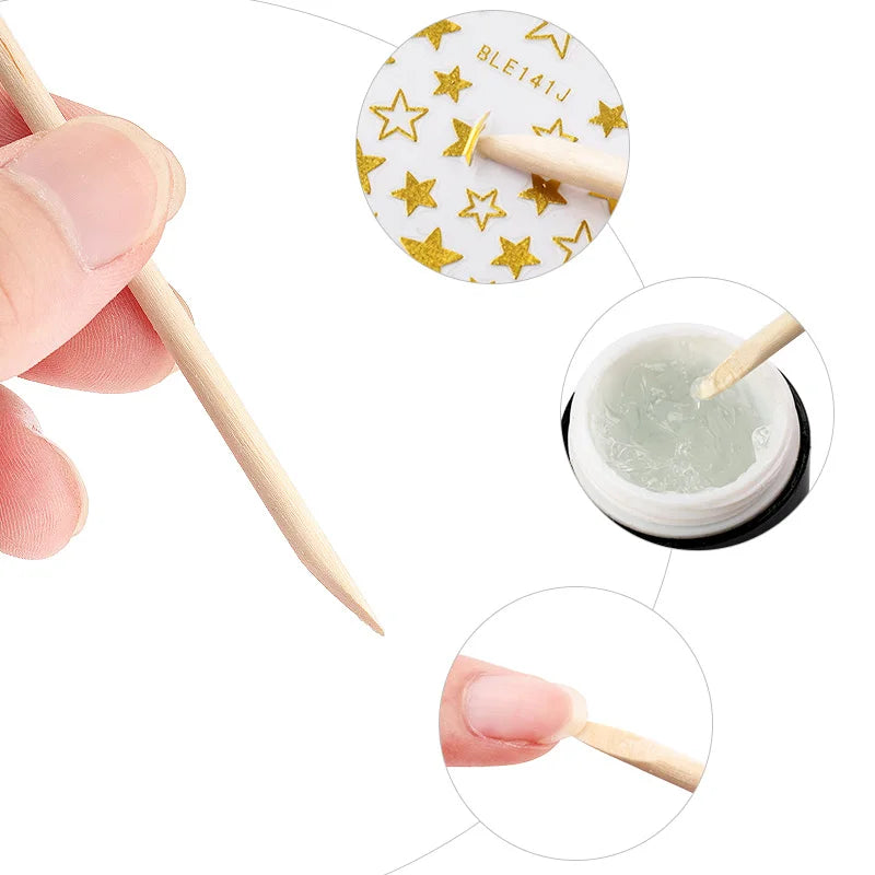 A set of natural wood nail art pusher sticks with gold star accents and a small container of green polish.