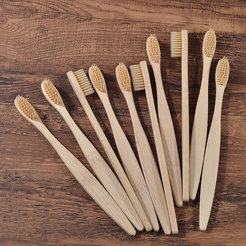 Une collection de dix brosses à dents en bambou debout sur une surface en bois.