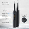A black electric dental scaling and whitening tool with a silicone handle and rechargeable battery is shown on a white surfac