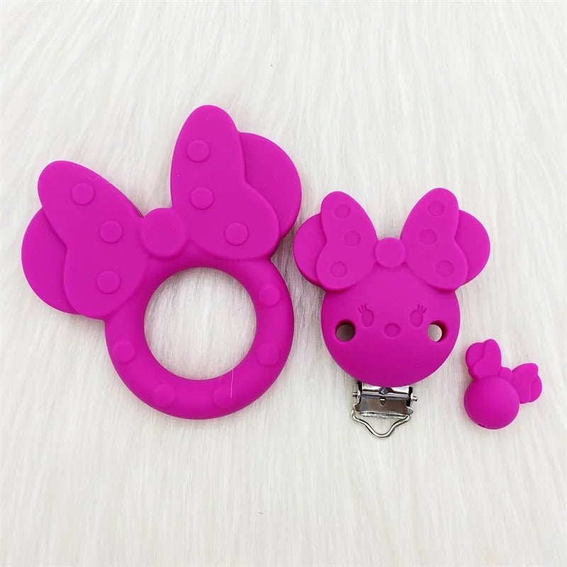 Doudou en silicone rose vif en forme de papillon avec un clip pour le soin oral du bébé.
