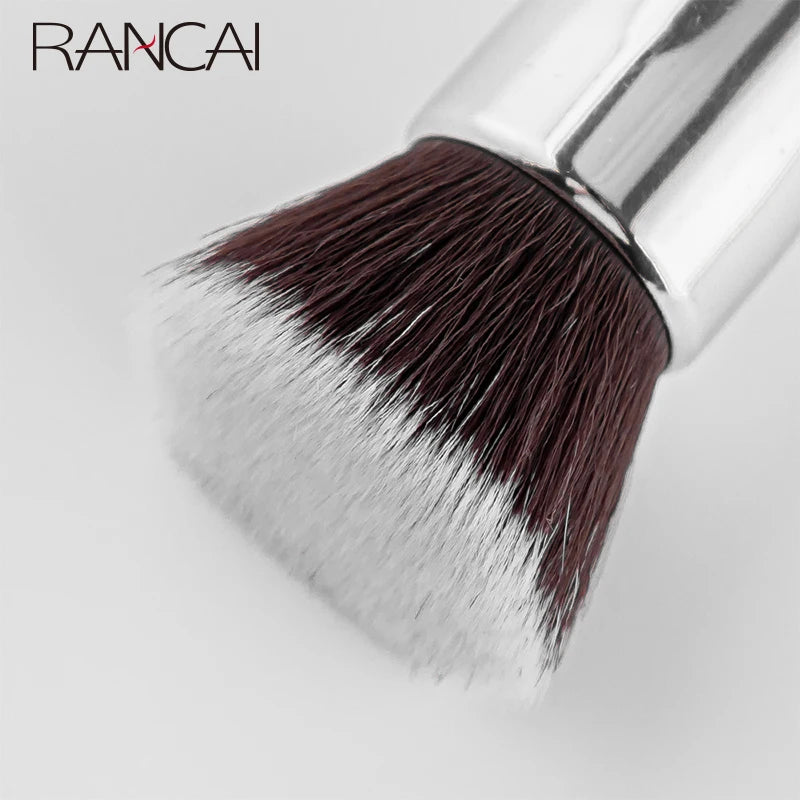 A flat top kabuki foundation brush with dark brown and light gray bristles shown against a white background.