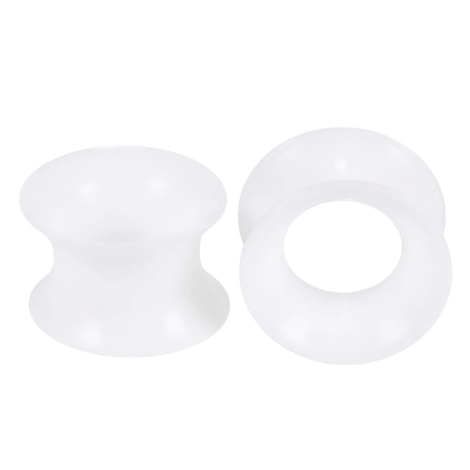 A pair of white flexible silicone ear tunnels and plugs.