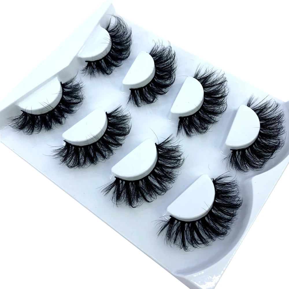 Un ensemble de huit paires de faux cils de renard noirs présentées dans un plateau blanc.