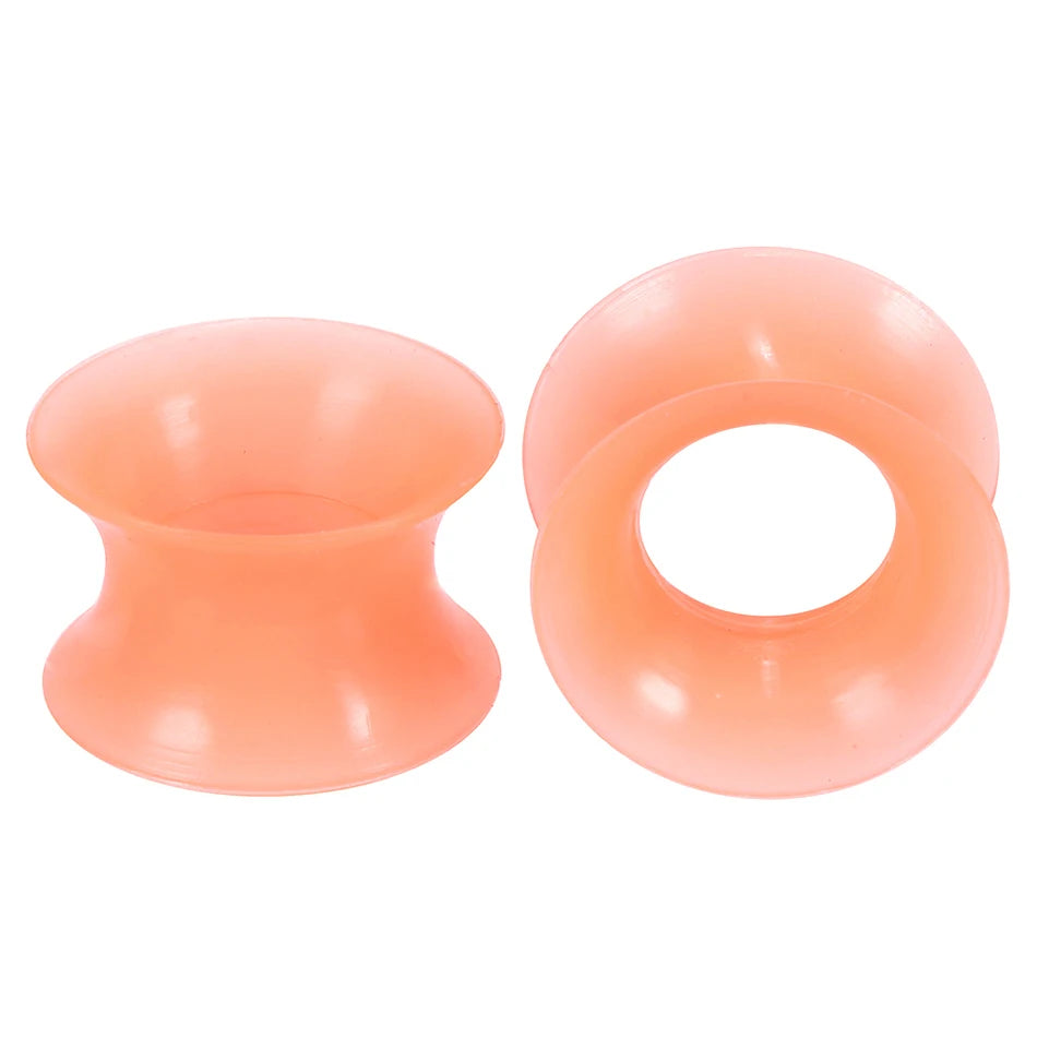 A pair of translucent peach silicone ear tunnels and plugs.