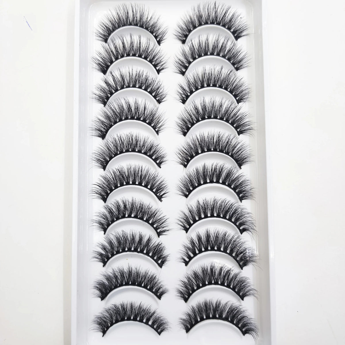 A display of natural 3D mink false eyelashes arranged in rows.