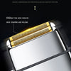 Close-up of a silver electric shaver head with a gold mesh, designed for shaving and hair removal.