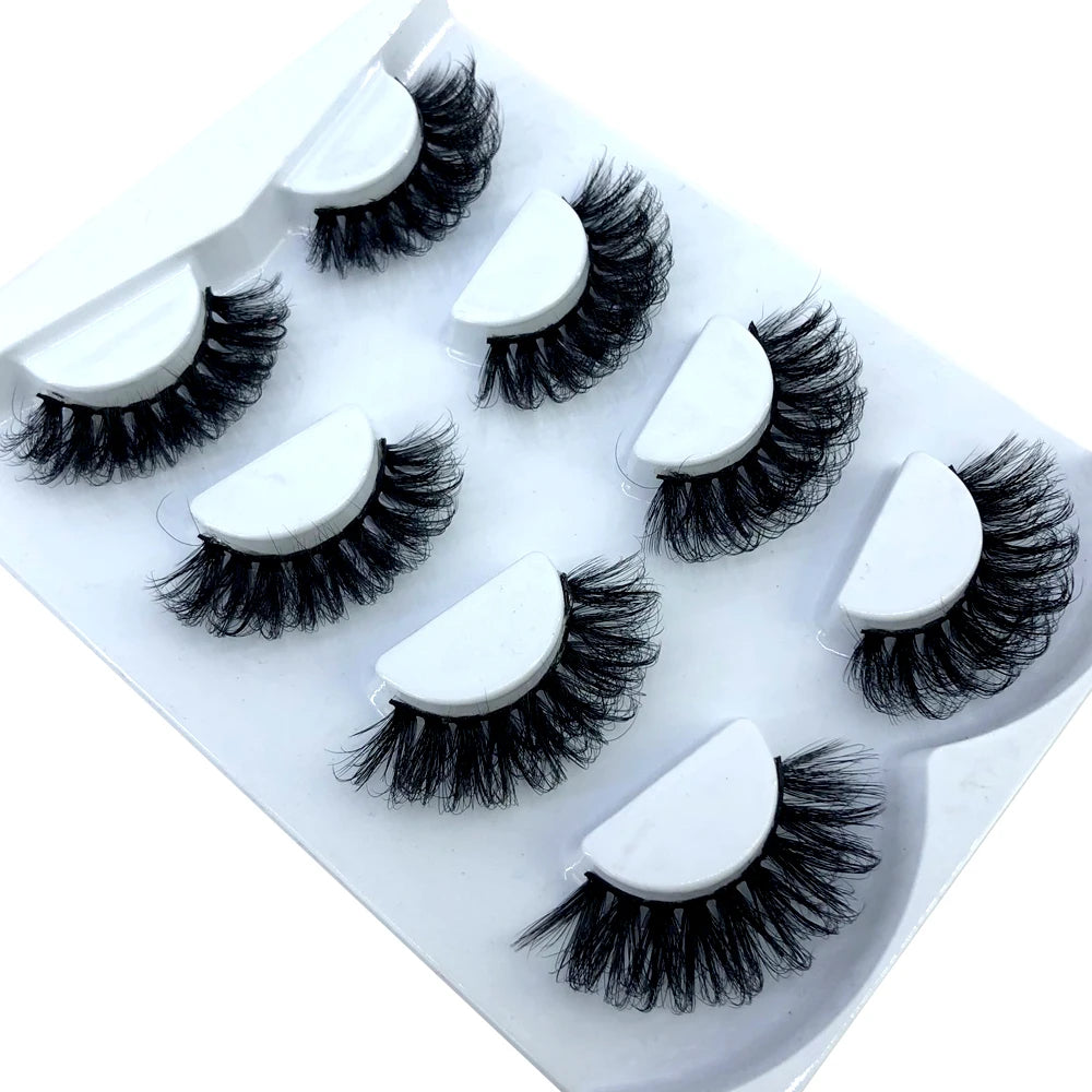 Un ensemble de huit paires de faux cils de renard noir dans un plateau en plastique blanc.