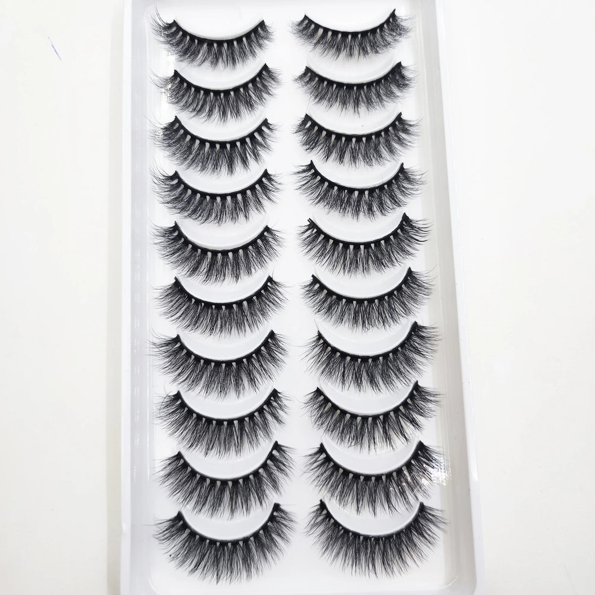 A plastic tray containing multiple pairs of natural mink false eyelashes for cosmetic use.