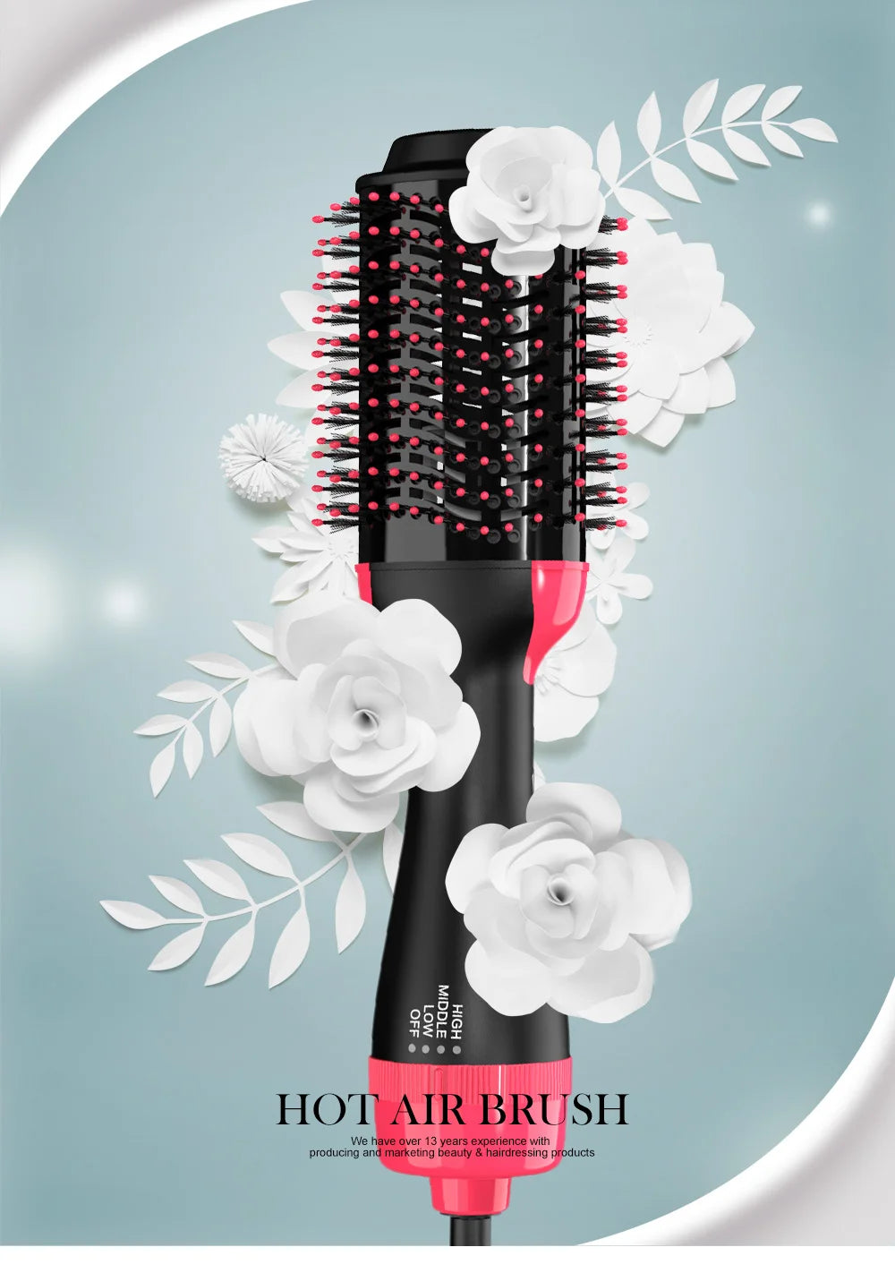 A black hot air brush hair dryer with pink accents surrounded by white roses and leaves.