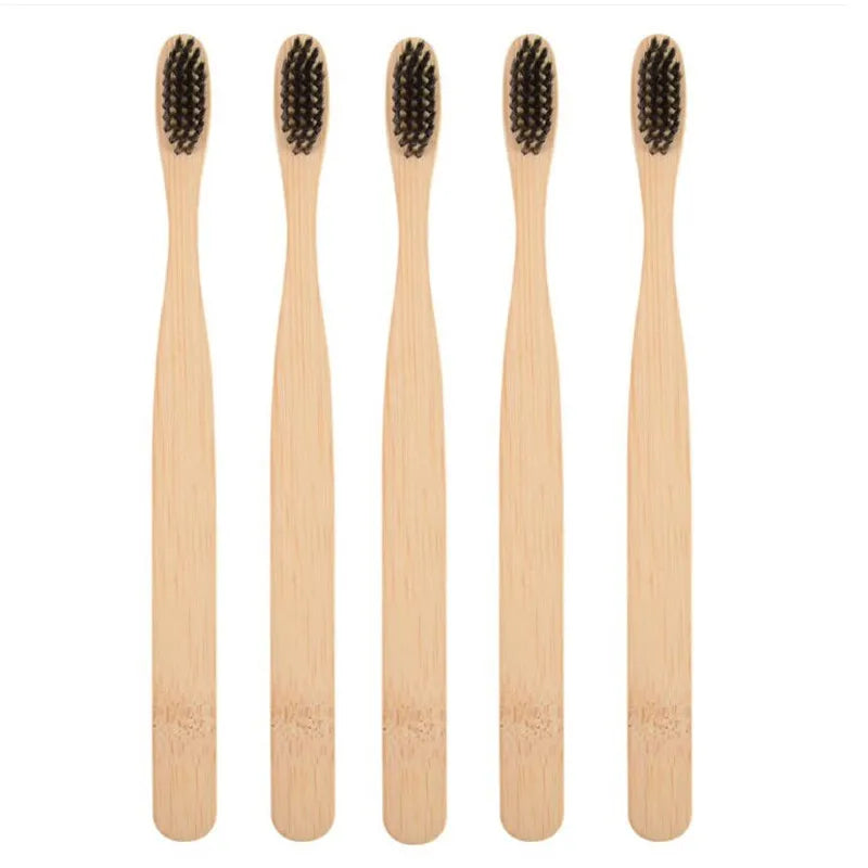 Four natural bamboo toothbrushes shown vertically in light wood tones