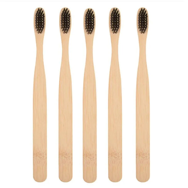 Four natural bamboo toothbrushes shown vertically in light wood tones