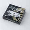 A black box containing a single stainless steel razor blade with a single edge.