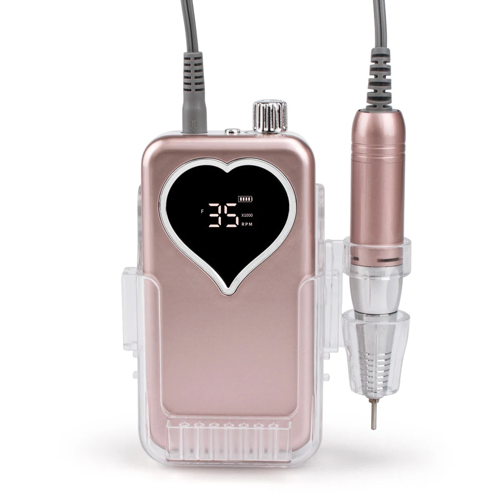 A pink cordless rechargeable nail drill device with a heart-shaped body and attached power cord.