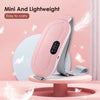 A pink electric massager belt is shown lying on a light pink stand with white feathers in the background.