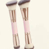 A pair of precision double-ended makeup foundation brushes with pink and rose gold handles and fluffy synthetic bristles.