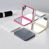 A set of double-sided portable makeup mirrors in pink, gold, and gray colors displayed on a white surface.