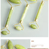 Jade gua sha facial massager tool with a light green stone and gold handle displayed on a light background.
